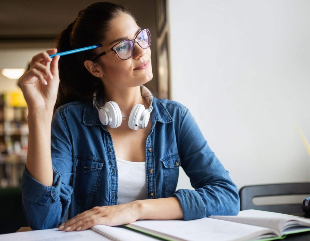 Young professional thinking while studying at a desk